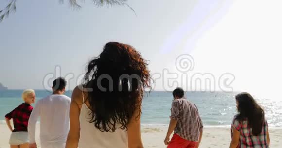 年轻女孩欢迎你和快乐的人一起在沙滩上水上奔跑游客一起在海上度假视频的预览图