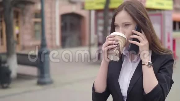 在市中心年轻的成功女商人使用智能手机职业女性雇主与她交谈视频的预览图