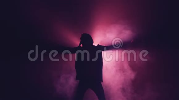 戴面具的男人在烟雾中跳舞的剪影视频的预览图
