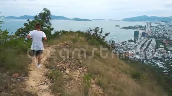 适合英俊的运动男性锻炼人在山上奔跑城市景色视频的预览图