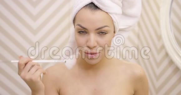 微笑的女性在毛巾上化妆视频的预览图