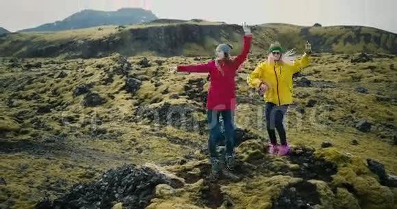 鸟瞰冰岛美丽的景观熔岩野覆盖着苔藓两个女人在山上跳舞跳视频的预览图