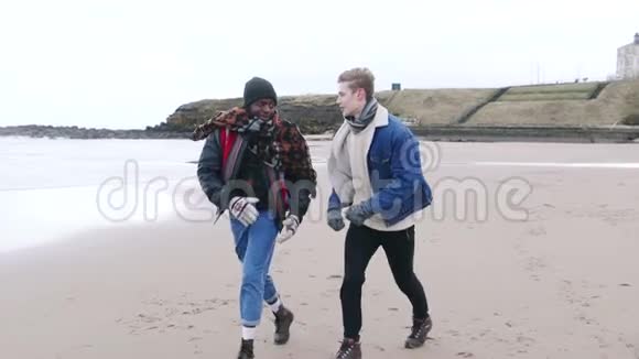 在冬季海滩散步的年轻人视频的预览图
