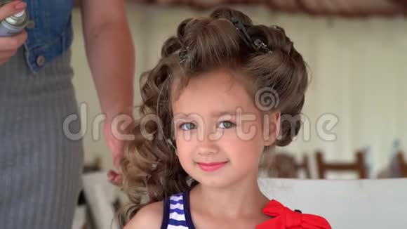 给小女孩做个化妆摄影那个可爱的女孩等待她什么时候完成一个发型视频的预览图