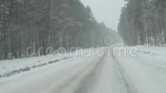 汽车在暴风雪中穿过森林透过挡风玻璃观看慢动作视频的预览图