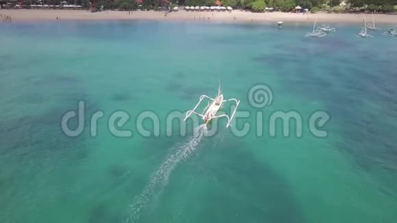 在美丽的水晶水上航行到陆地的传统渔船的空中拍摄视频的预览图