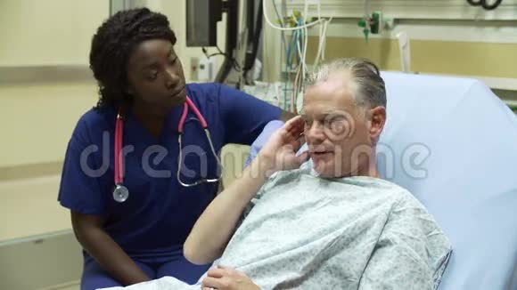 护士检查医院病床上的成年男性病人视频的预览图