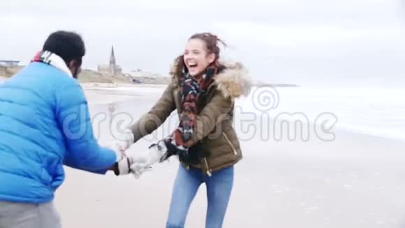 年轻夫妇在冬天的海滩上跳舞视频的预览图