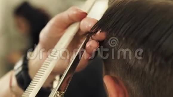 理发店的理发师用理发剪梳头发和理发把手上的理发师剪湿男性视频的预览图