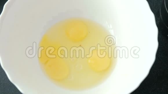 把三个新鲜鸡蛋放在白碗里视频的预览图