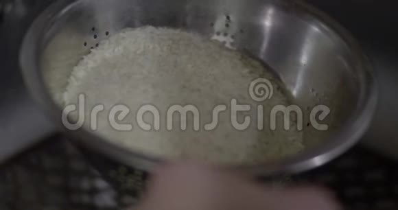男人在水槽里洗米饭视频的预览图