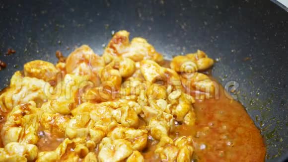 将玉米片和长码豆子放入黑色四氟乙烯锅中与香料咖喱酱一起炒视频的预览图