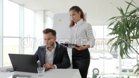 老板在桌上主任和员工助理在手工作报告秘书在手文件视频的预览图