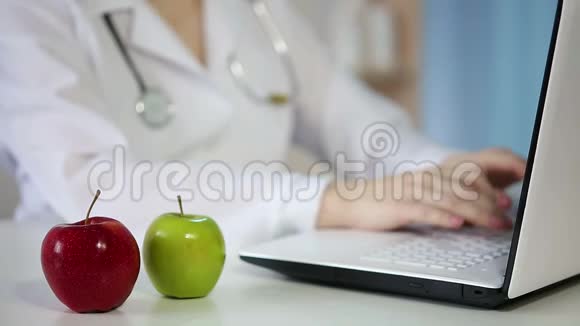 女MD在办公室工作用笔记本电脑打字餐桌上的苹果健康饮食视频的预览图