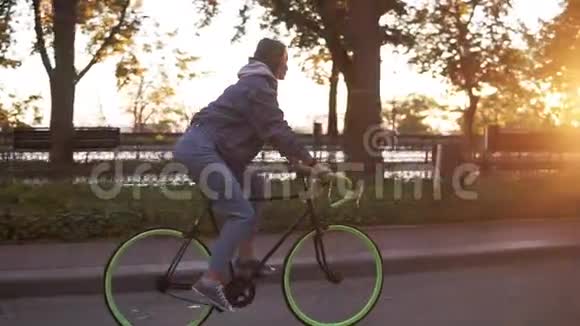 迷人的女性骑自行车在早晨公园或林荫大道一位骑着徒步自行车的年轻女子的侧景视频的预览图