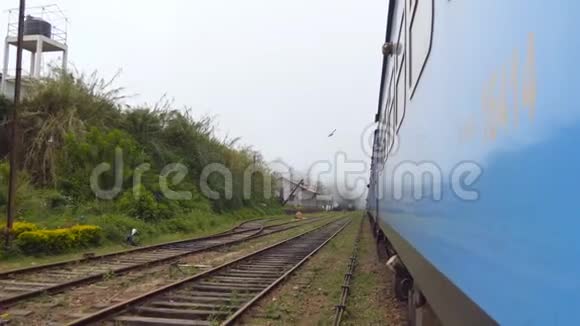 早上从老蓝火车穿过小村庄的门上低角度观看客运铁路运输视频的预览图