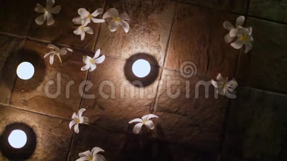 靠近漂亮的夜晚装饰在地板上安排蜡烛和布局花白色木兰浪漫视频的预览图