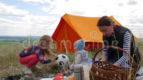 父母和孩子野餐他们将在帐篷里过夜旅行妇女和儿童放松视频的预览图