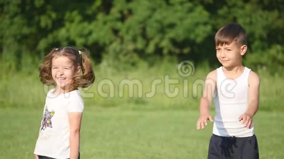 漂亮的女孩和男孩在户外做身体抽搐家庭在足球场上倾斜和做体育锻炼视频的预览图