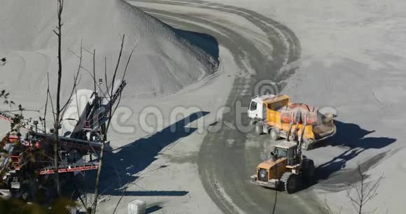 一台现代推土机在一个职业生涯中工作一台橙色推土机将石块装入自卸卡车视频的预览图