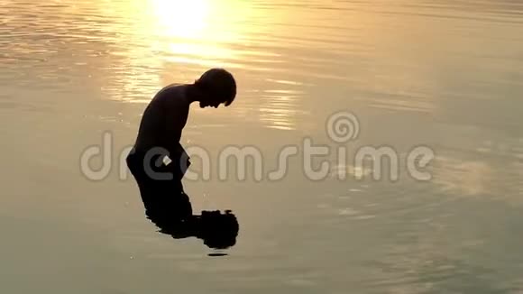 人看他的倒影扬起江水让它落在夕阳下视频的预览图