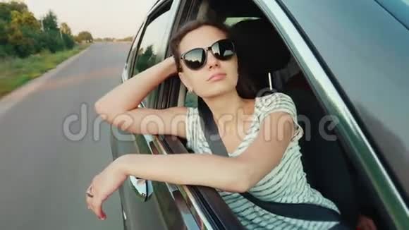 迷人的年轻女子望着车窗外梦想旅行视频的预览图