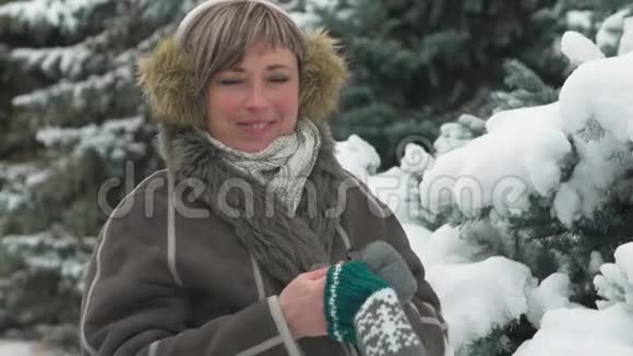 冬天森林里的女人戴着手套白雪皑皑的杉树视频的预览图