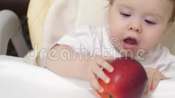 小孩子在桌子上玩红苹果视频的预览图