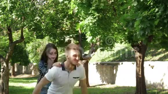 快乐的一对在公园里玩得开心的夫妇和男孩手中的女孩视频的预览图