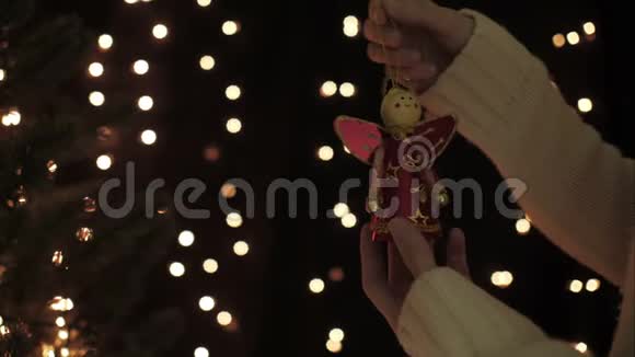女人在一棵圣诞树上装饰仙女花环背景是照明灯背景视频的预览图