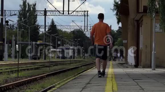 一个年轻人夏天在斯洛莫的火车站台上离开视频的预览图