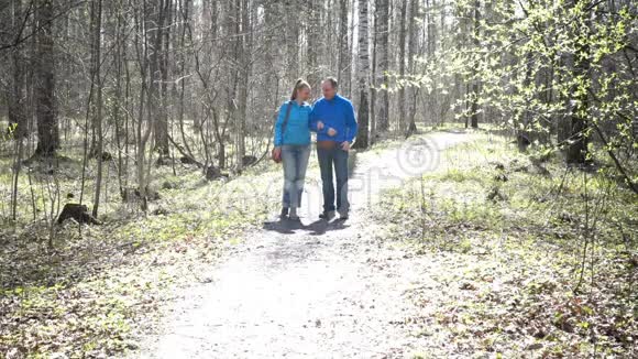 慢动作幸福的爱人男人和女人走在春天的公园里视频的预览图