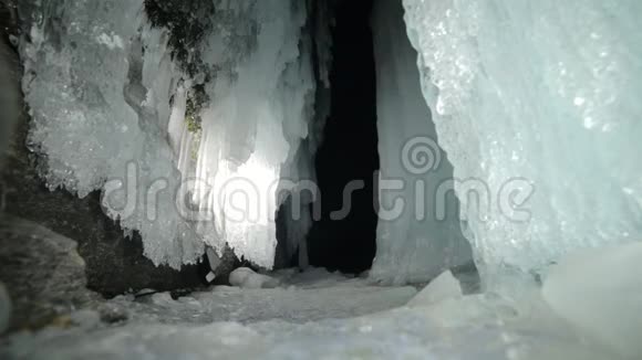 在贝加尔湖冰洞旅行的人去冬岛旅行背包客正在冰窟散步旅行者看着视频的预览图
