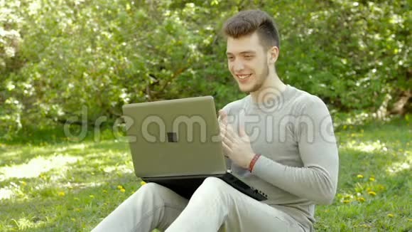 快乐的小男孩在公园玩电脑游戏视频的预览图
