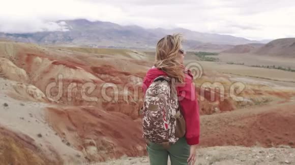 带背包的女孩欣赏山景山里旅行者的肖像旅游女孩视频的预览图