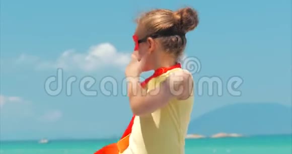 穿着超级英雄服装的漂亮小女孩穿着红色斗篷和英雄的面具背景图视频的预览图