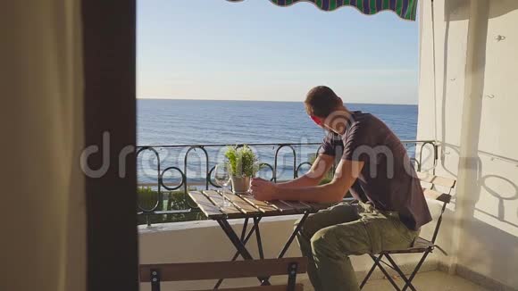 一个男人从内哈的阳台上看海洋西班牙视频的预览图