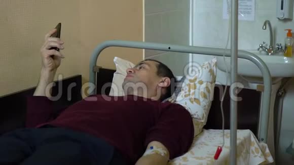 静脉注射药物通过静脉注射进入静脉医院病房里的一个男人躺在床上一个男人视频的预览图