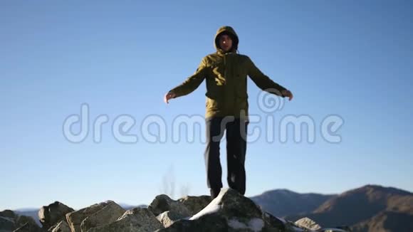 一个年轻人站在山顶上享受着周围的自由和美丽慢动作1920x1080全高清视频的预览图