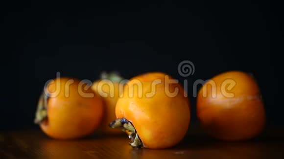 成熟的异国橙甜甜柿在黑色视频的预览图