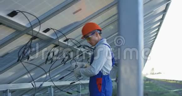 工人连接太阳能电池板的电线视频的预览图