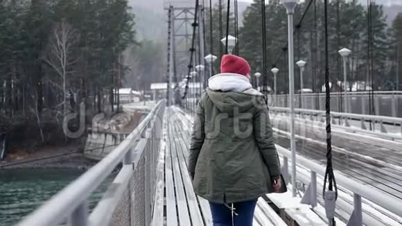 一个年轻的女孩走过大桥过河到公园享受生活和自由慢动作1920x1080视频的预览图