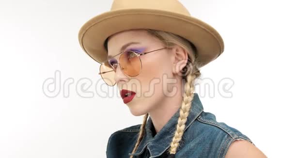 戴着两条辫子和玻璃的帽子的模特看起来像个牛仔女孩视频的预览图