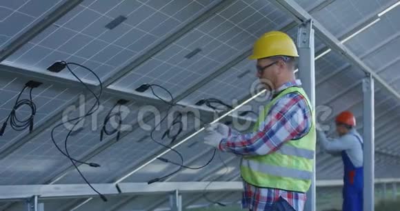 工人连接太阳能电池板的电线视频的预览图