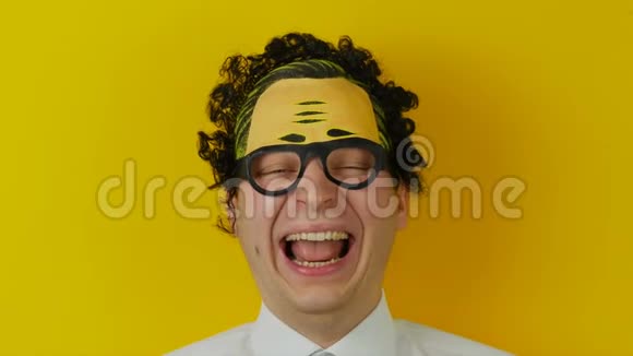 黄色墙壁背景上的年轻卷曲笑人的肖像有趣而欢快的人类情感视频的预览图