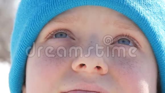 一个长着蓝眼睛脸上长着雀斑的少年戴着蓝帽子抬头看着视频的预览图