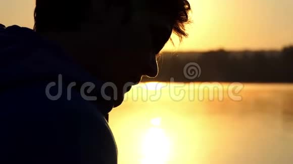 幸福的女人看日落时在湖边的照片视频的预览图