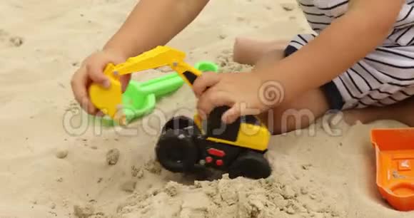 玩拉德的小孩在沙子里玩玩具挖掘机视频的预览图