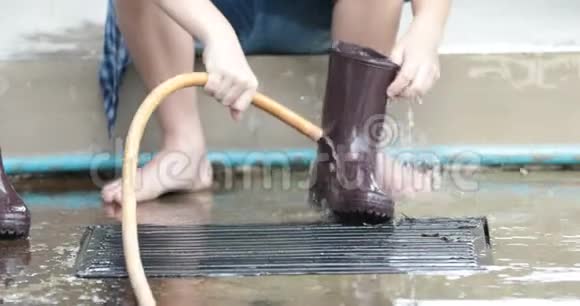 亚洲男孩在家用水管洗靴子视频的预览图