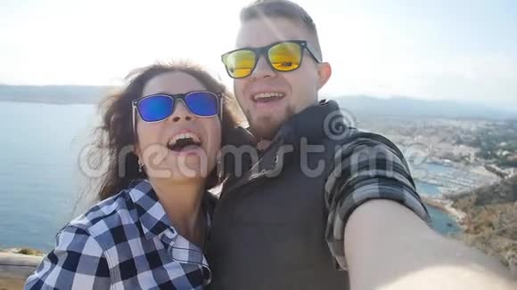 幸福的年轻情侣在海边的山上自拍视频的预览图